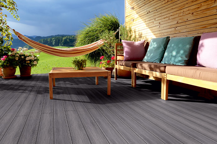 Terrasse grise en WPC avec meubles en bois, hamac et vue panoramique
